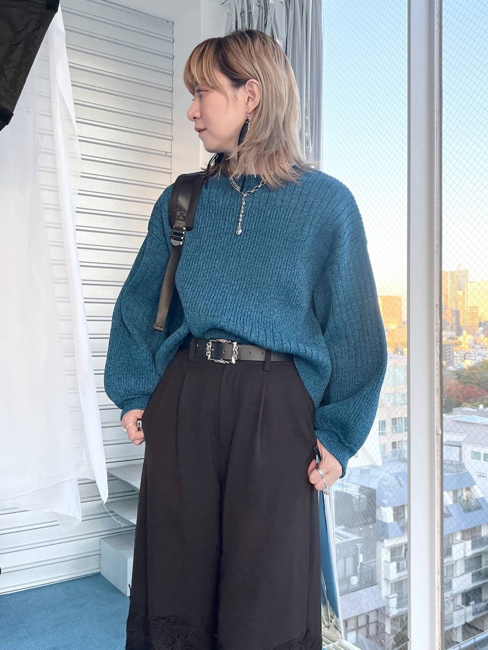 ブラック系のブーツ、ブルー系のニット/セーター、ブラック系のその他パンツを着用したレディースの冬コーディネートの3枚目の写真