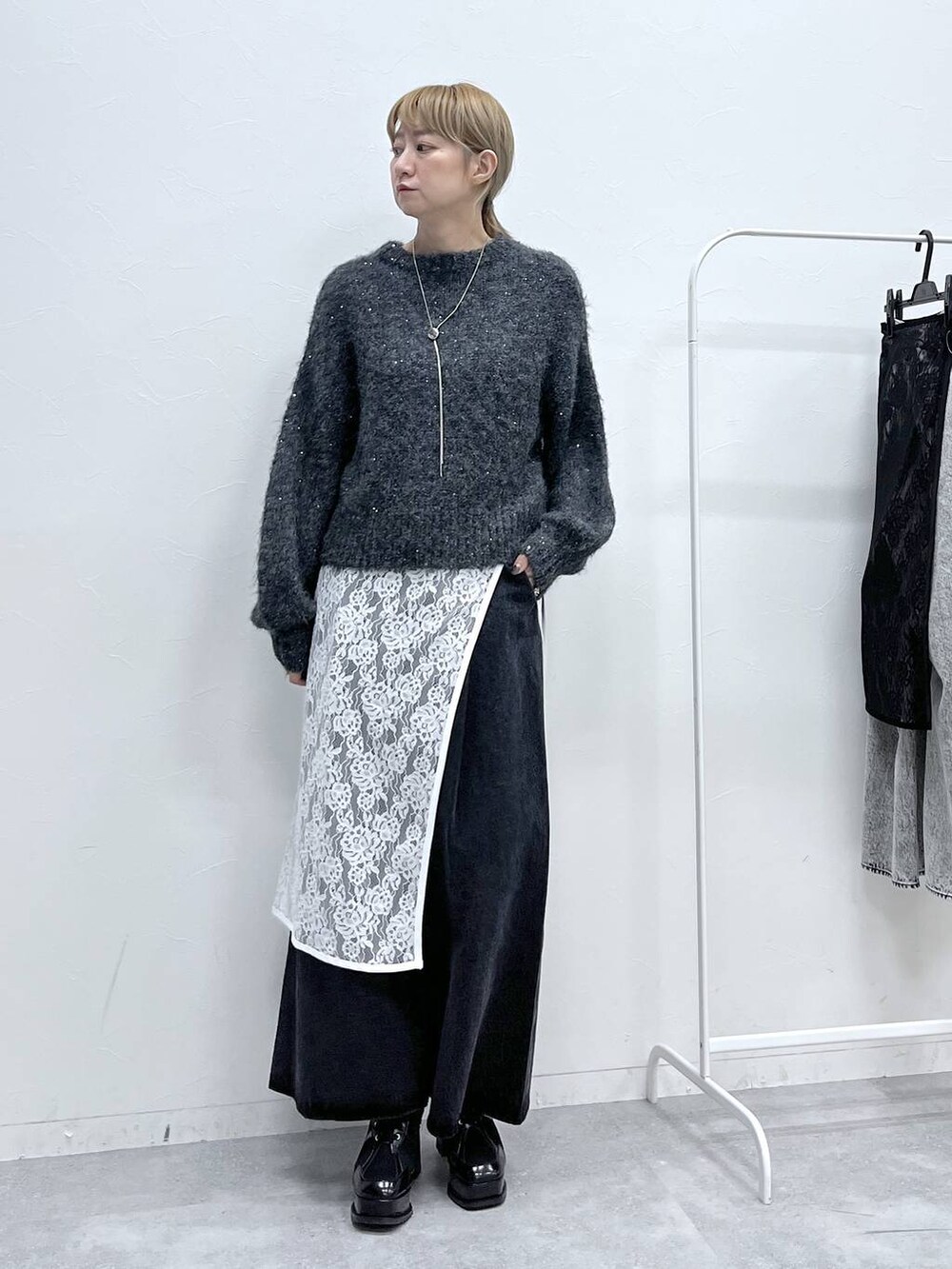 ブラック系のブーツ、グレー系のニット/セーター、ブラック系のデニムパンツを着用したレディースの秋コーディネートの8枚目の写真