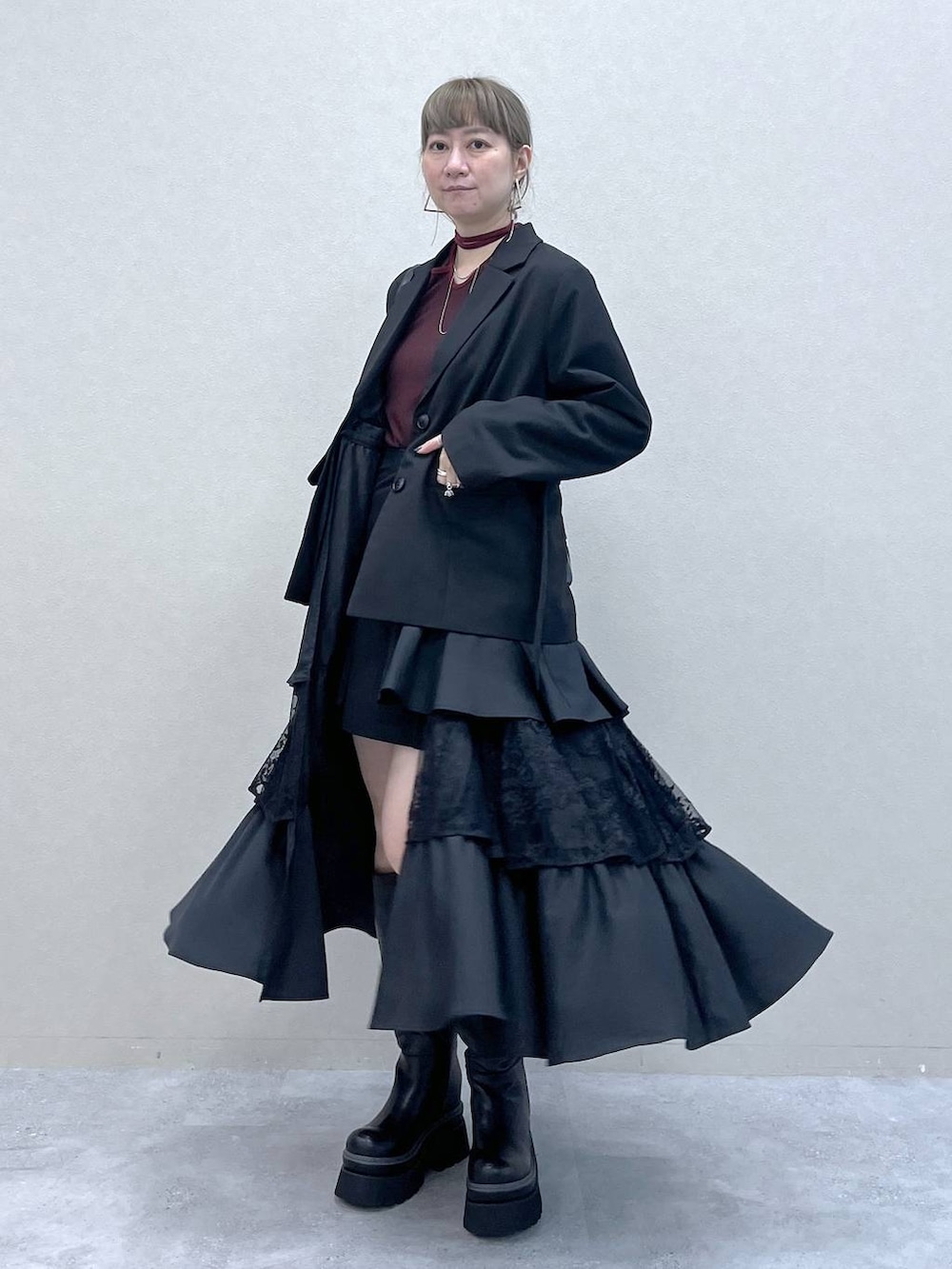 ブラック系のショルダーバッグ、その他のスカート、ブラック系のブーツを着用したレディースの秋コーディネートの5枚目の写真