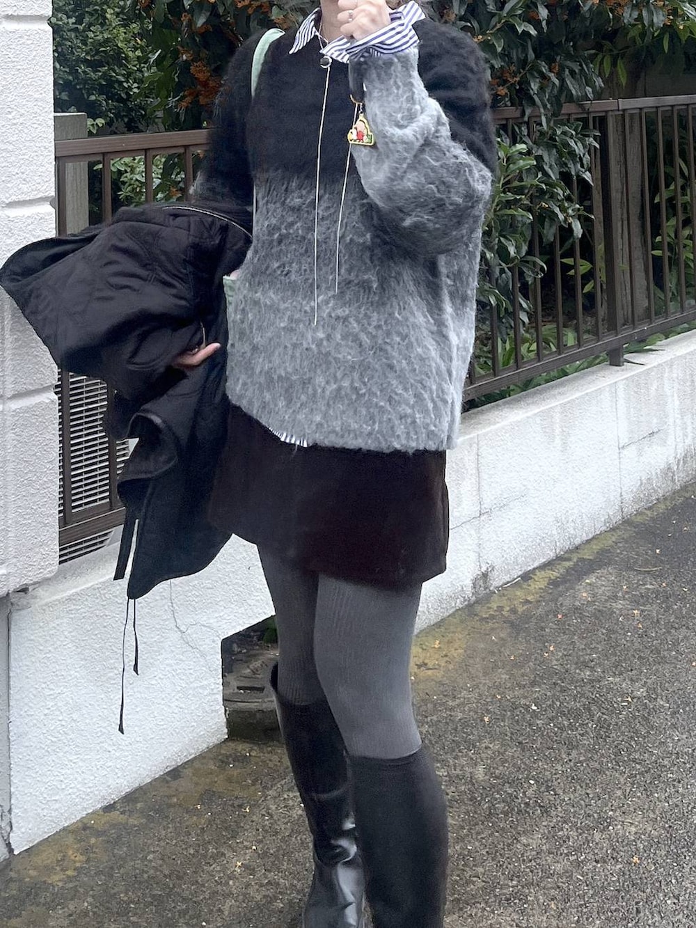 ブラック系のニット/セーターを着用したレディースの秋コーディネートの8枚目の写真