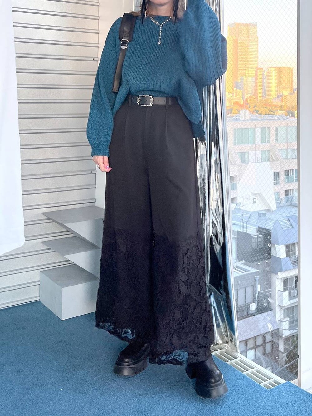 ブラック系のブーツ、ブルー系のニット/セーター、ブラック系のその他パンツを着用したレディースの冬コーディネートの5枚目の写真