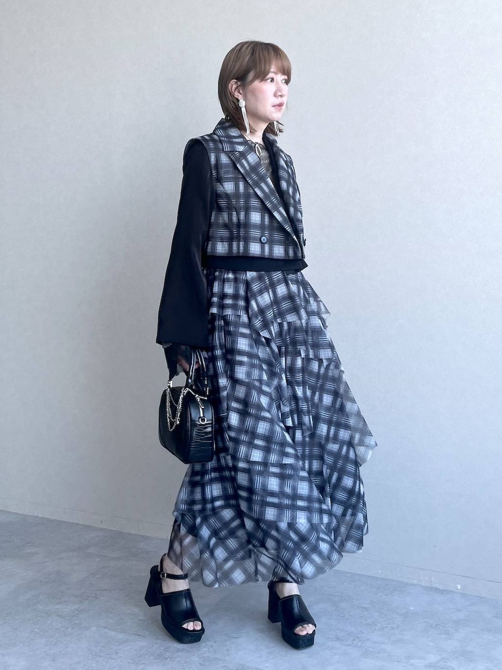 ブラック系のTシャツ/カットソー、ブラック系のテーラードジャケット、ブラック系のショルダーバッグを着用したレディースの春コーディネートの7枚目の写真