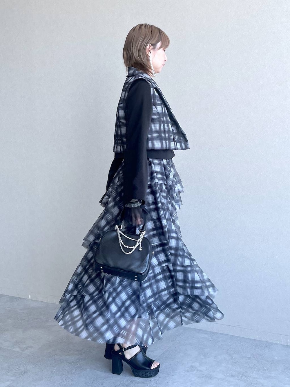 ブラック系のTシャツ/カットソー、ブラック系のテーラードジャケット、ブラック系のショルダーバッグを着用したレディースの春コーディネートの6枚目の写真