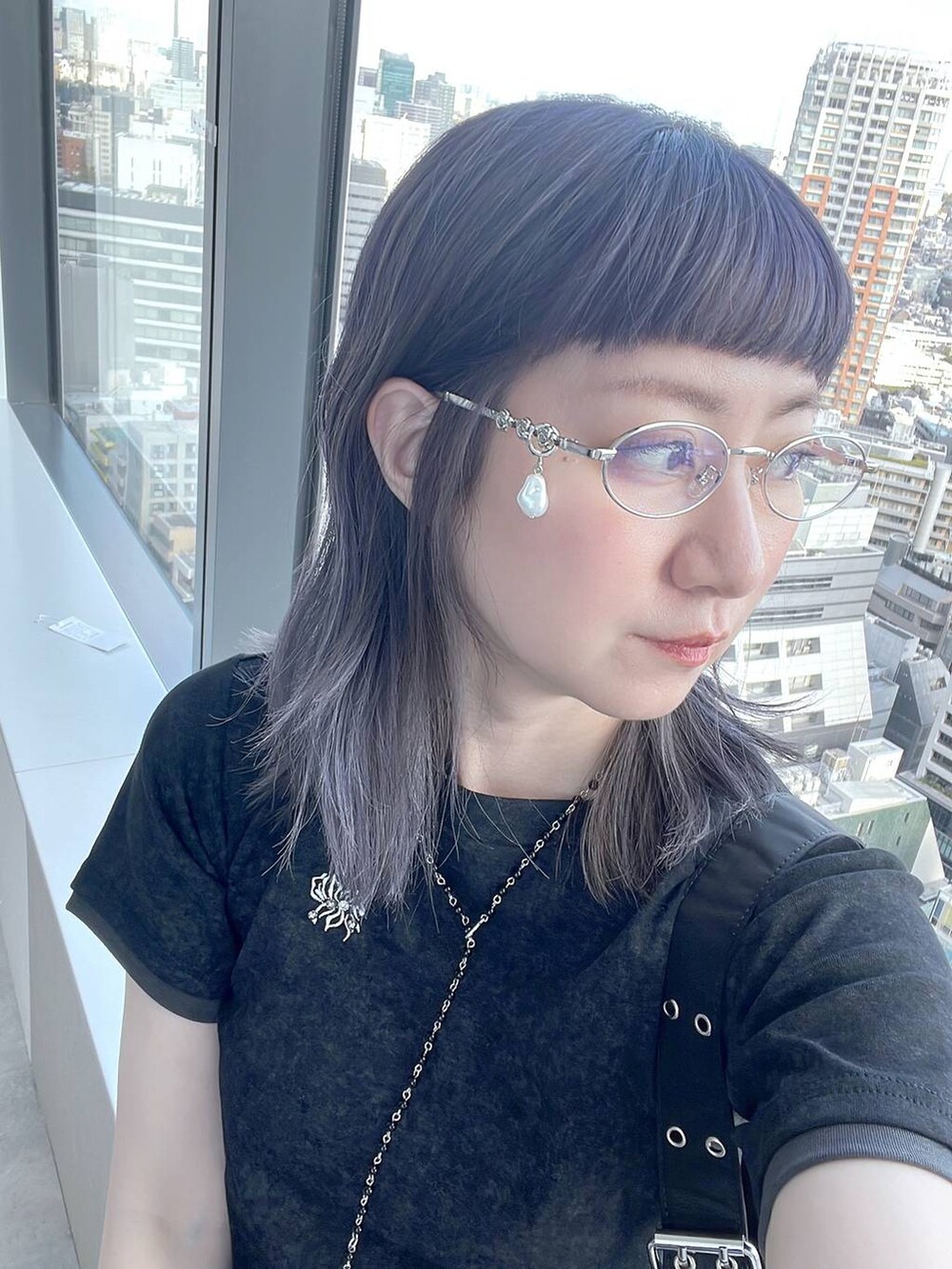 ブラック系のTシャツ/カットソー、ブラック系のネックレス、シルバー系のメガネを着用したレディースの春コーディネートの3枚目の写真