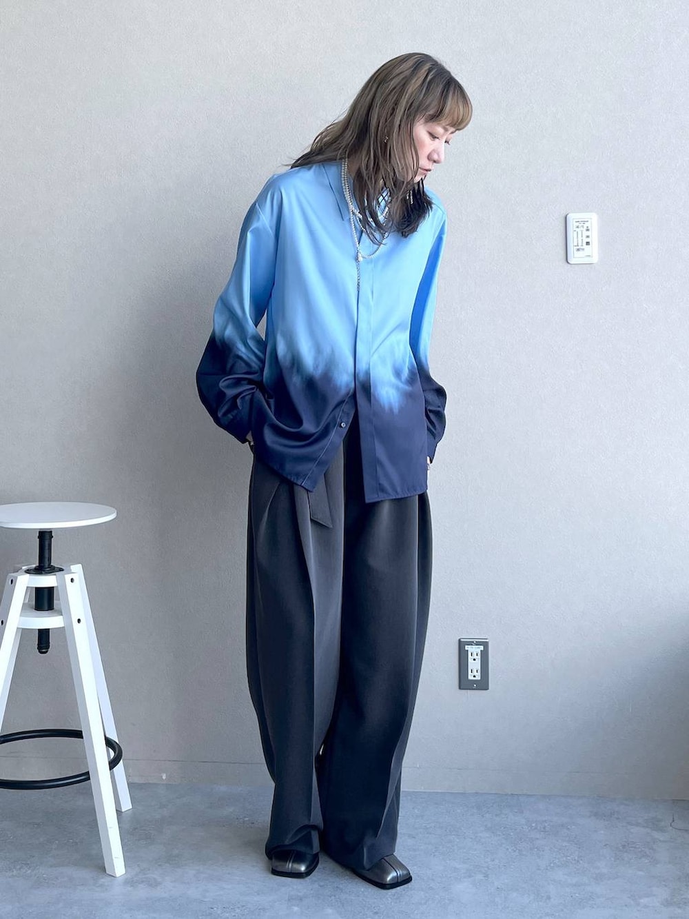 シルバー系のブーツ、ブラック系のピアス（両耳用）、シルバー系のネックレスを着用したレディースの秋コーディネートの2枚目の写真