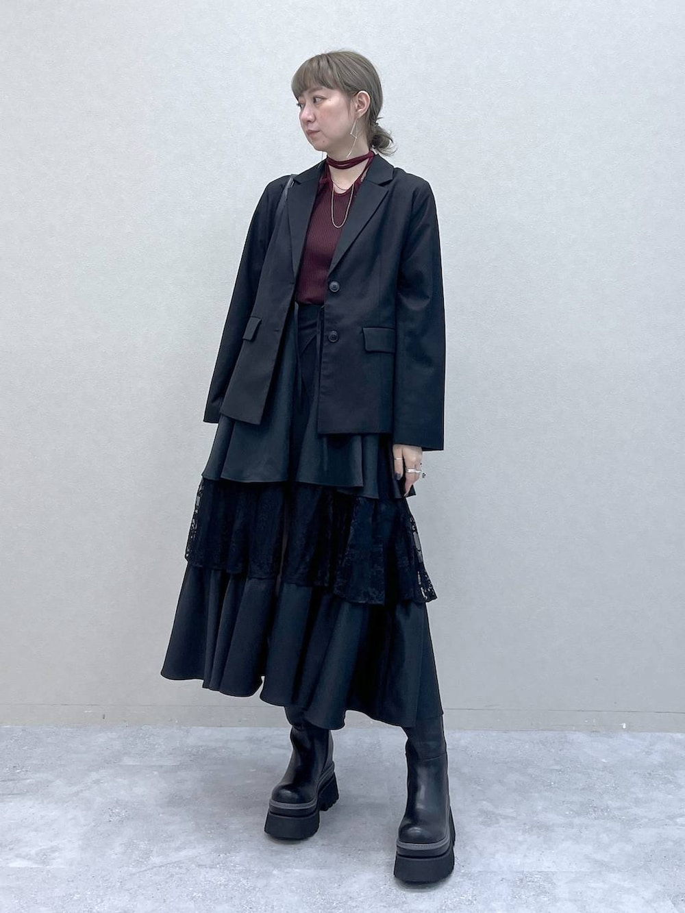 ブラック系のショルダーバッグ、その他のスカート、ブラック系のブーツを着用したレディースの秋コーディネートの7枚目の写真