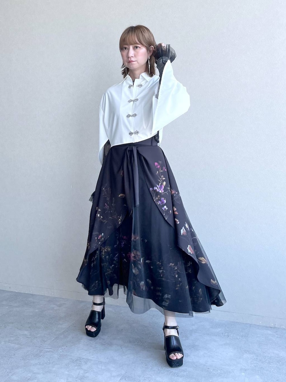 ブラック系のスカート、ブラック系のTシャツ/カットソー、ホワイト系のシャツ/ブラウスを着用したレディースの春コーディネートの6枚目の写真