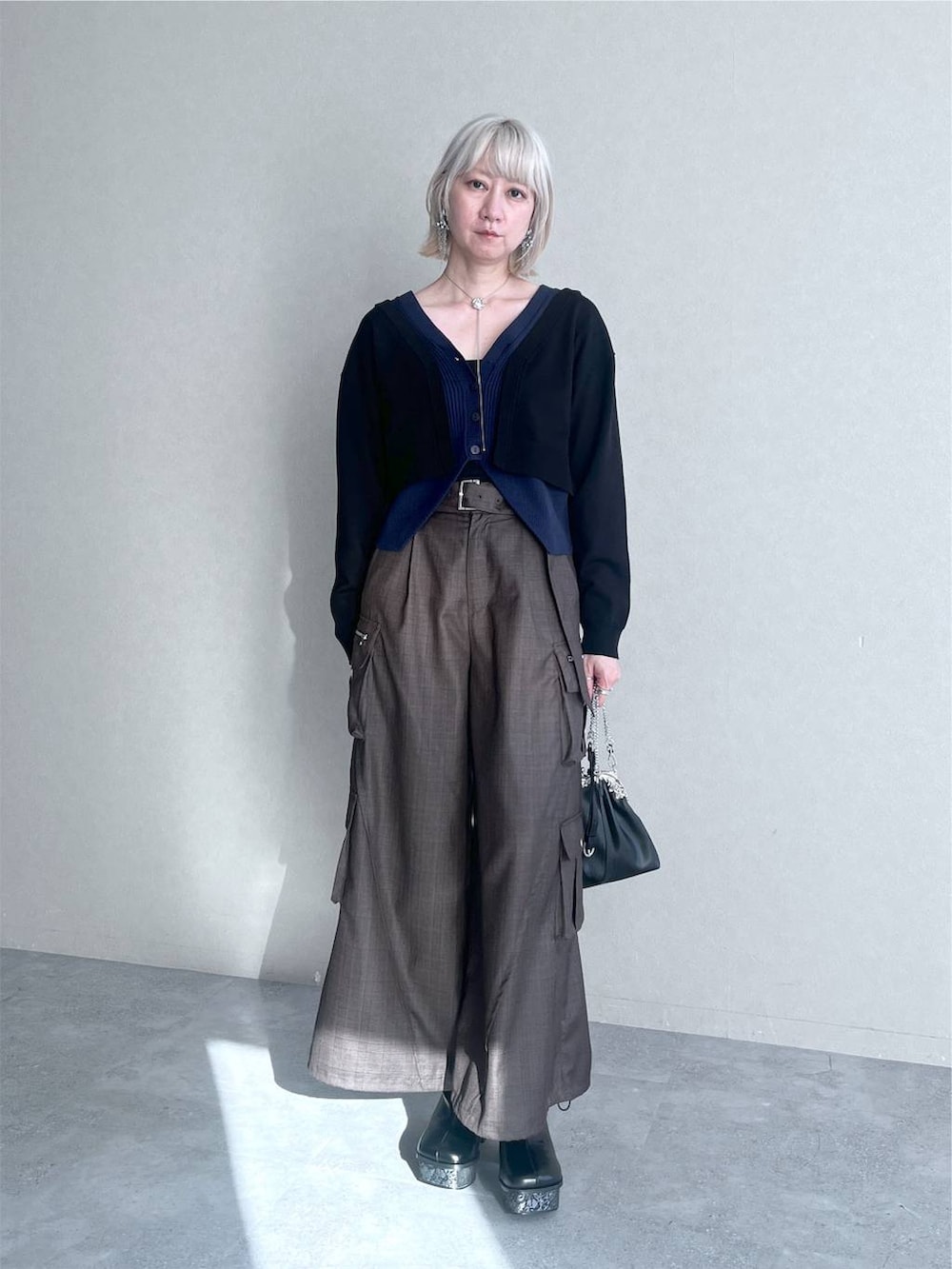 ブラック系のカーディガン/ボレロ、ブラウン系のカーゴパンツ、シルバー系のネックレスを着用したレディースの夏コーディネートの3枚目の写真