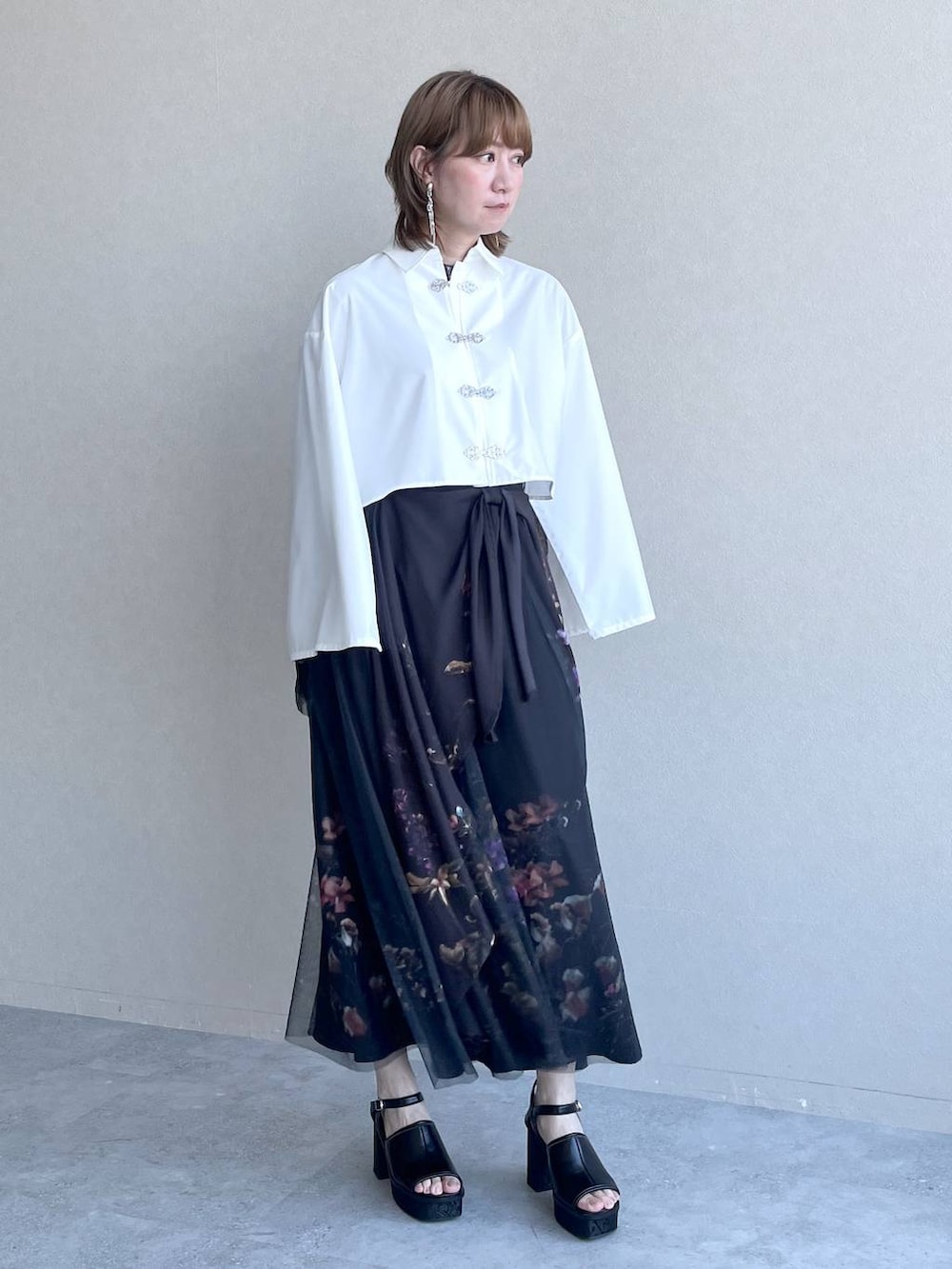 ブラック系のスカート、ブラック系のTシャツ/カットソー、ホワイト系のシャツ/ブラウスを着用したレディースの春コーディネートの2枚目の写真