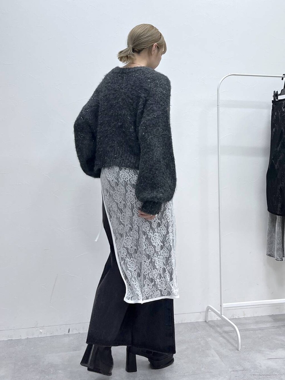 ブラック系のブーツ、グレー系のニット/セーター、ブラック系のデニムパンツを着用したレディースの秋コーディネートの5枚目の写真