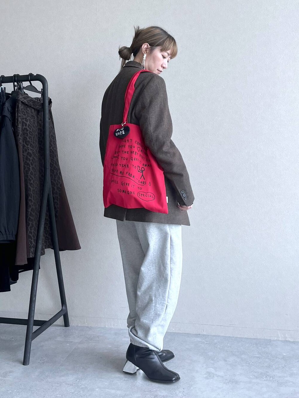 ブラック系のブーツ、レッド系のトートバッグ、グレー系のその他パンツを着用したレディースの冬コーディネートの4枚目の写真