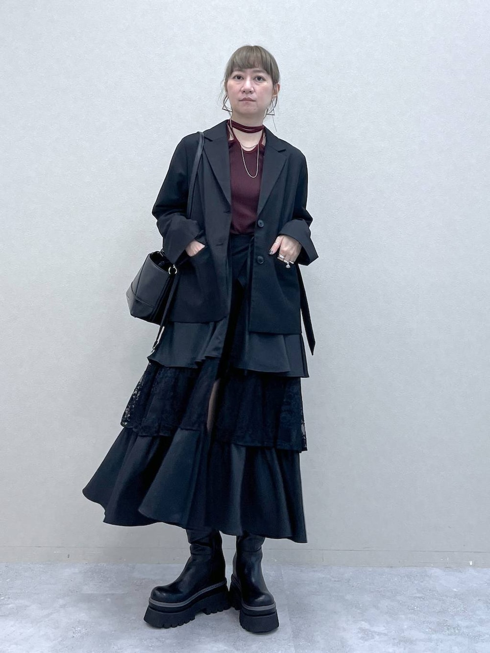 ブラック系のショルダーバッグ、その他のスカート、ブラック系のブーツを着用したレディースの秋コーディネートの9枚目の写真