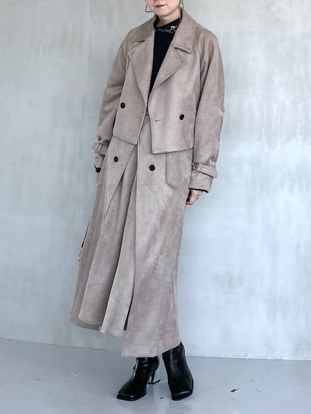 グレー系のブーツ、ブラック系のショルダーバッグ、ベージュ系のトレンチコートを着用したレディースの夏コーディネートの4枚目の写真