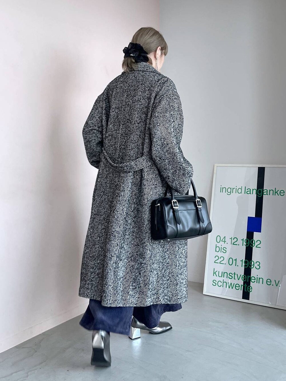 グレー系のステンカラーコート、ブラック系のボストンバッグ、シルバー系のブーツを着用したレディースの秋コーディネートの7枚目の写真