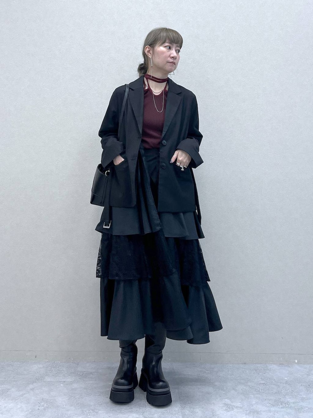 ブラック系のショルダーバッグ、その他のスカート、ブラック系のブーツを着用したレディースの秋コーディネートの8枚目の写真