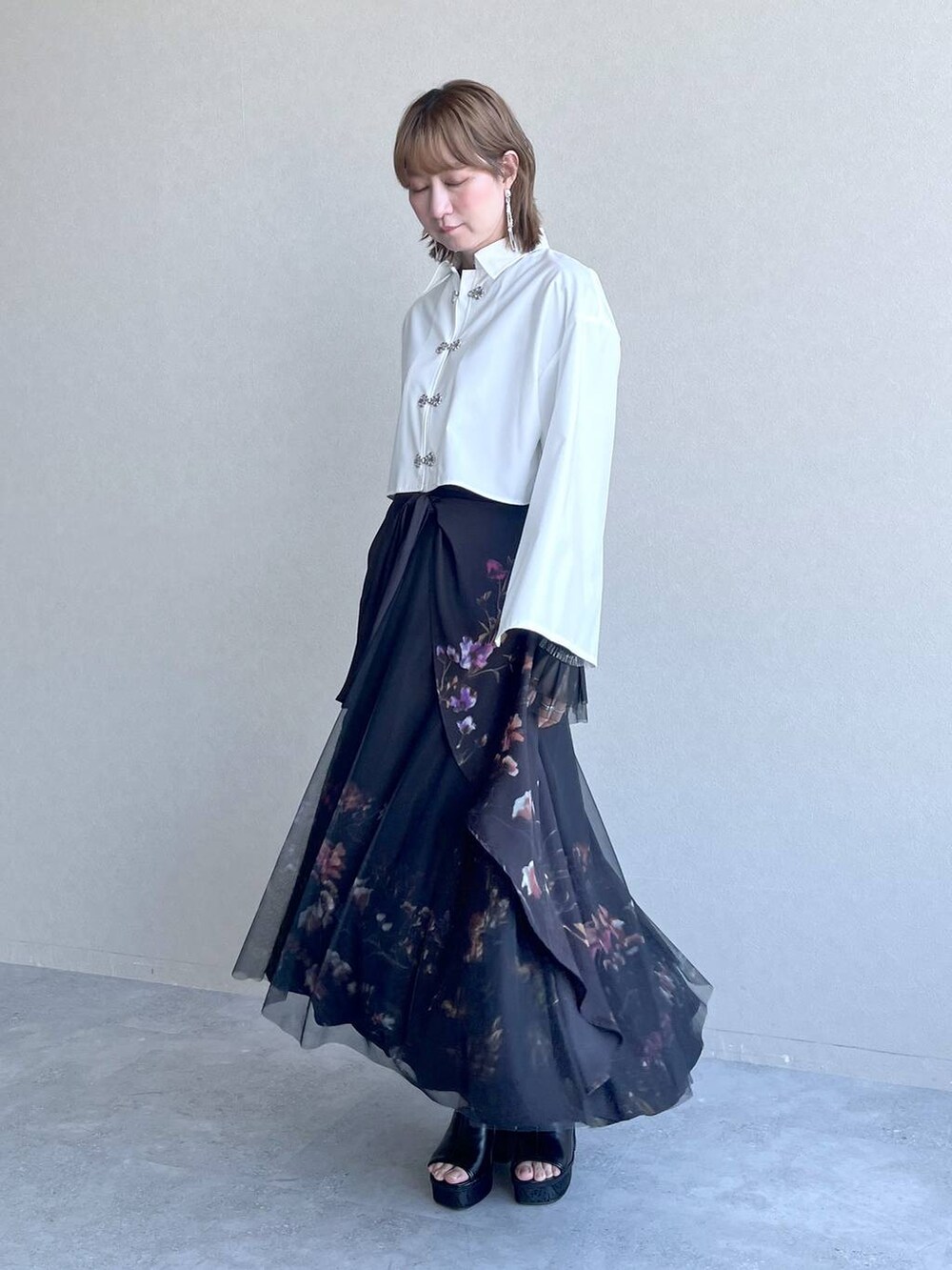 ブラック系のスカート、ブラック系のTシャツ/カットソー、ホワイト系のシャツ/ブラウスを着用したレディースの春コーディネートの8枚目の写真