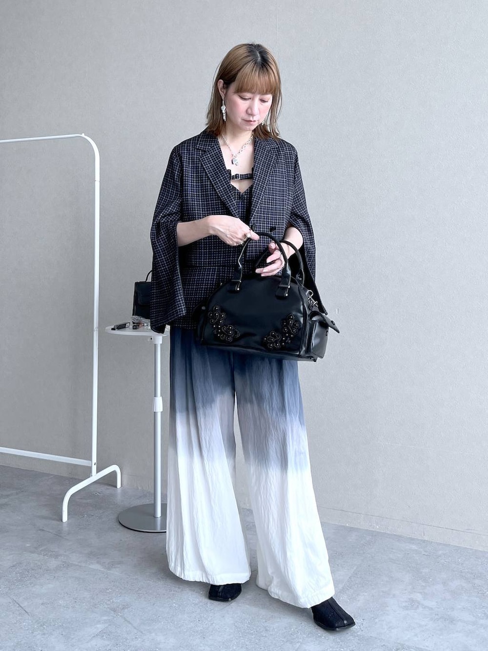 ブラック系のブーツ、ブラック系のボストンバッグ、ブラック系のその他パンツを着用したレディースの冬コーディネートの2枚目の写真