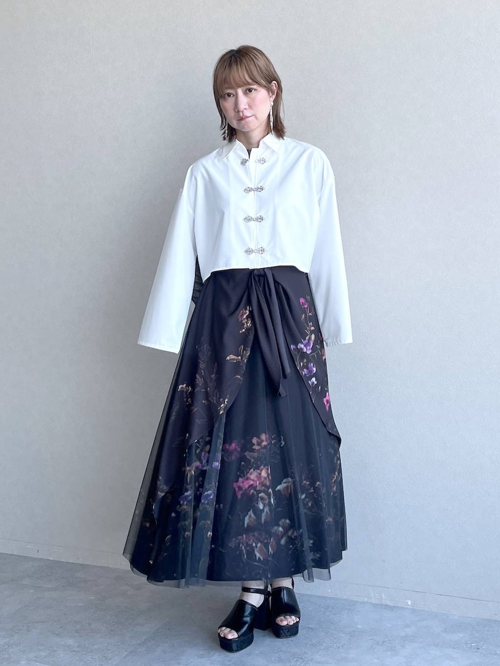 ブラック系のスカート、ブラック系のTシャツ/カットソー、ホワイト系のシャツ/ブラウスを着用したレディースの春コーディネートの9枚目の写真