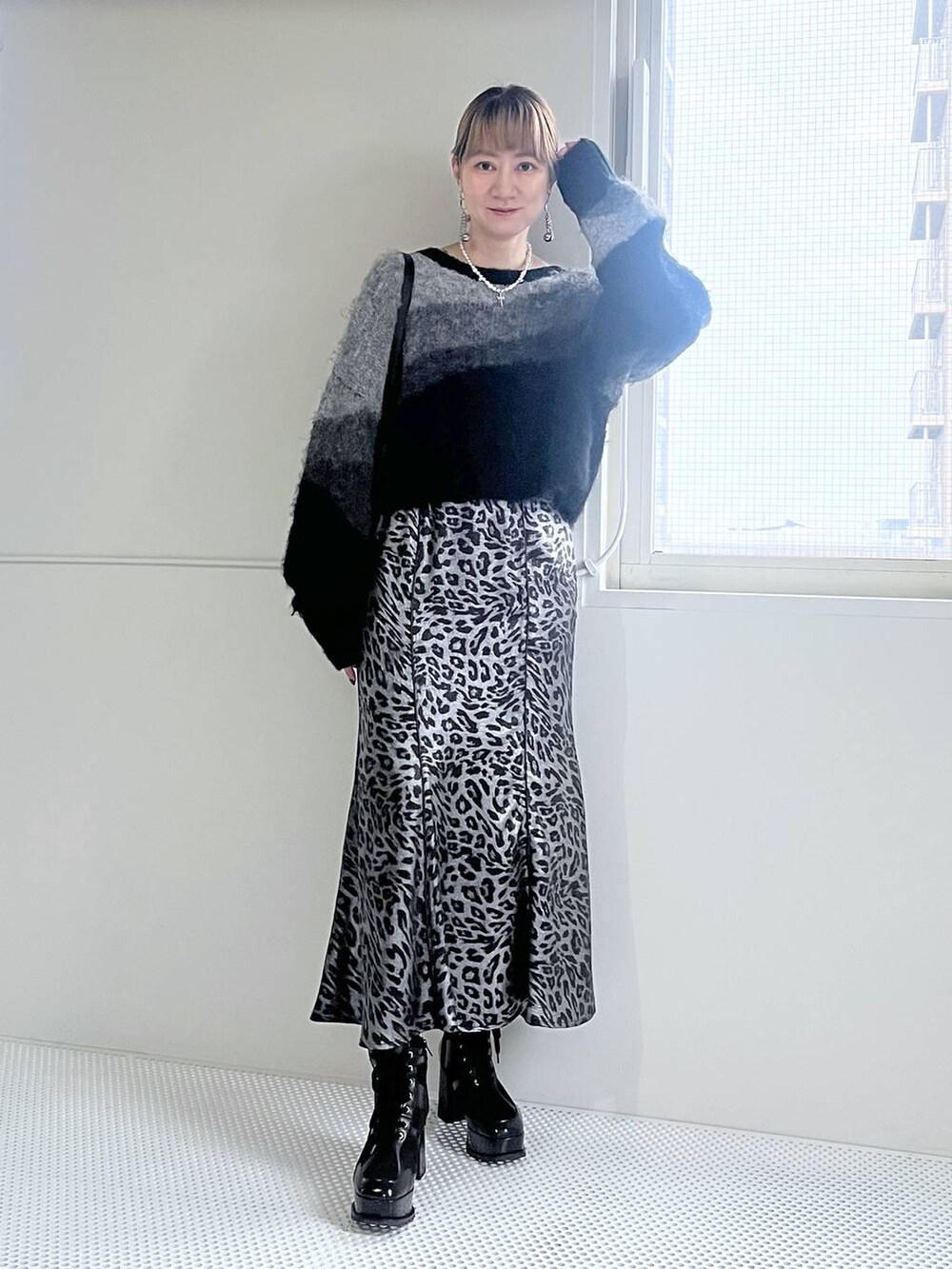 ブラック系のブーツ、ブラック系のショルダーバッグ、ブラック系のニット/セーターを着用したレディースの秋コーディネートの8枚目の写真