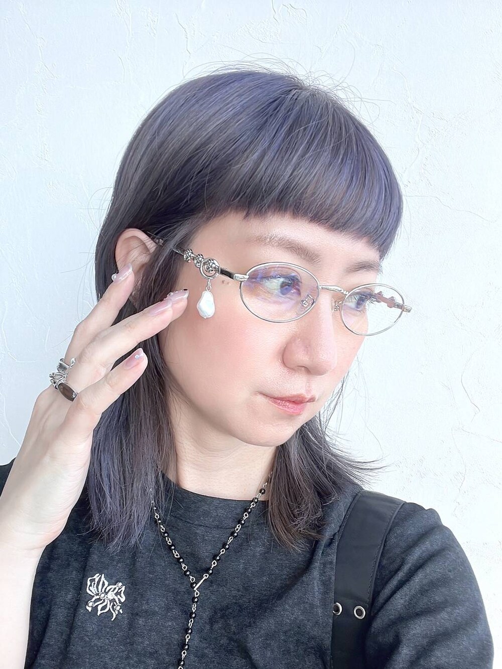 ブラック系のTシャツ/カットソー、ブラック系のネックレス、シルバー系のメガネを着用したレディースの春コーディネートの2枚目の写真