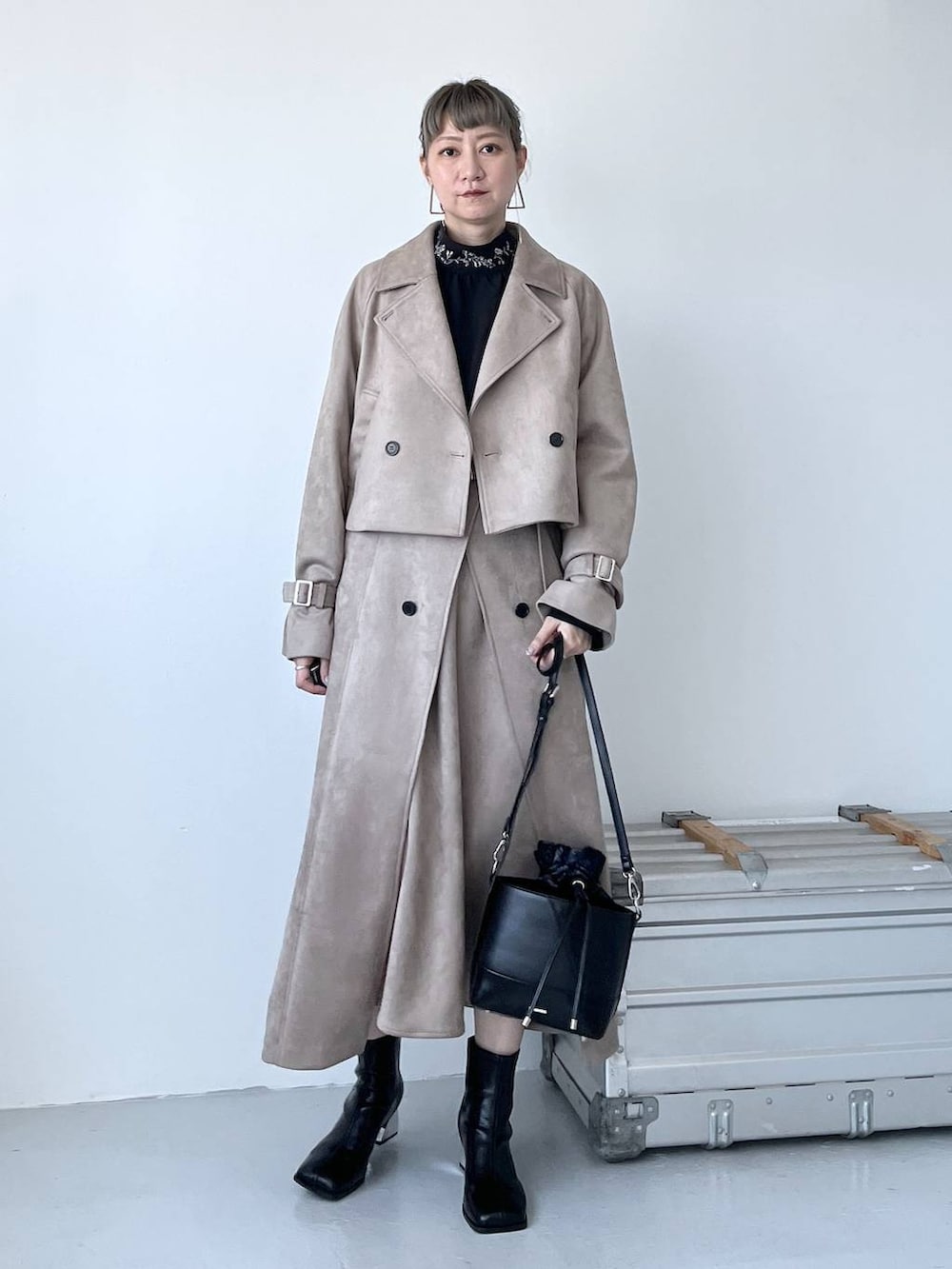 グレー系のブーツ、ブラック系のショルダーバッグ、ベージュ系のトレンチコートを着用したレディースの夏コーディネートの6枚目の写真