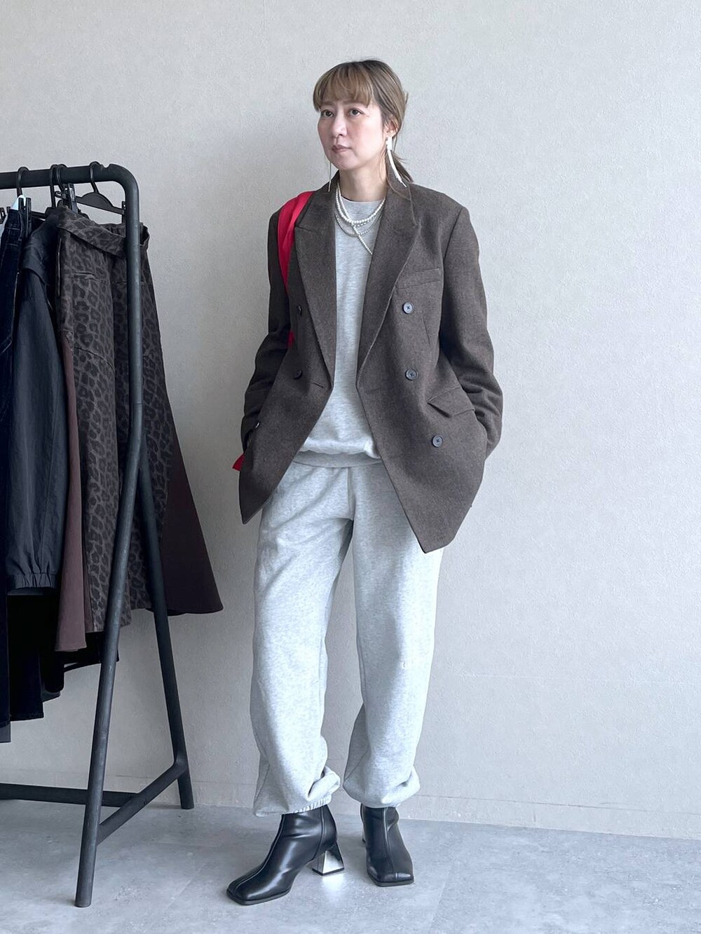 ブラック系のブーツ、レッド系のトートバッグ、グレー系のその他パンツを着用したレディースの冬コーディネートの7枚目の写真