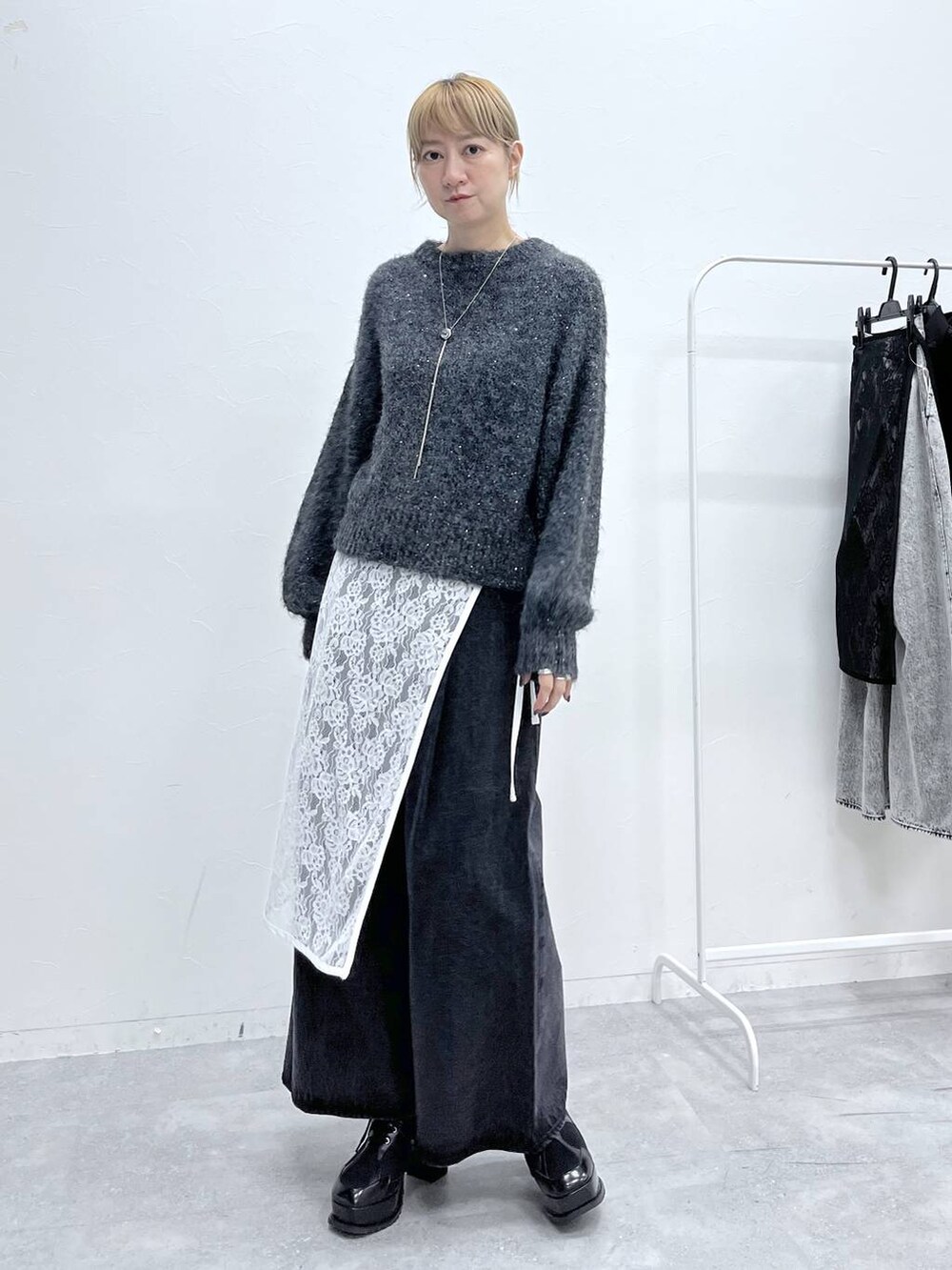 ブラック系のブーツ、グレー系のニット/セーター、ブラック系のデニムパンツを着用したレディースの秋コーディネートの4枚目の写真