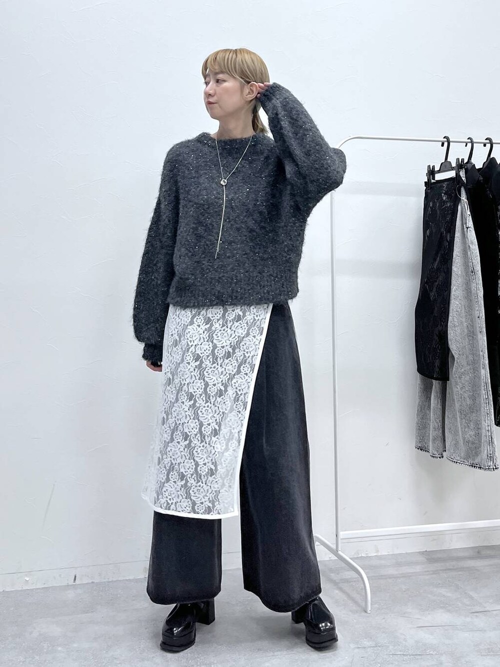 ブラック系のブーツ、グレー系のニット/セーター、ブラック系のデニムパンツを着用したレディースの秋コーディネートの2枚目の写真