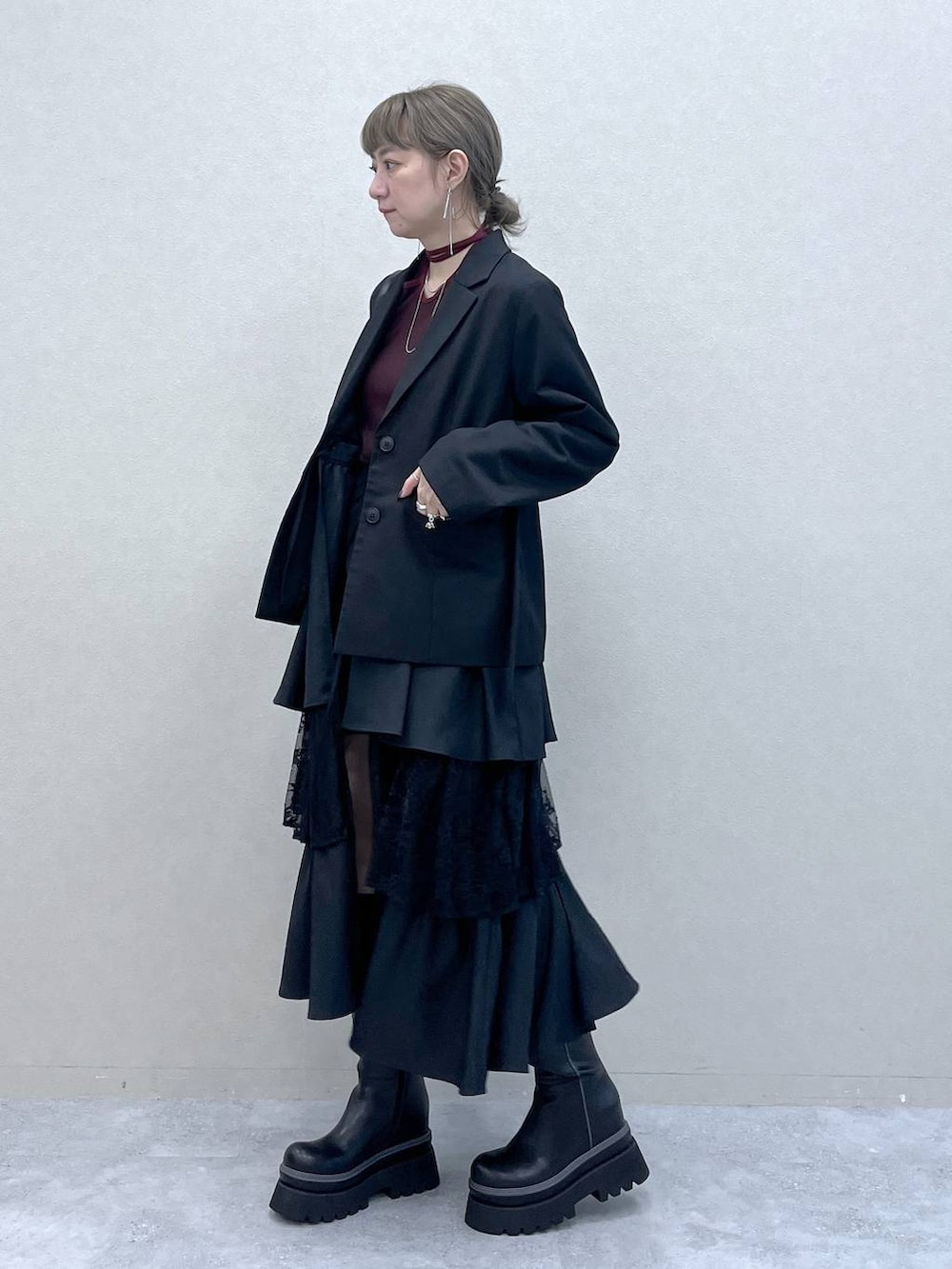 ブラック系のショルダーバッグ、その他のスカート、ブラック系のブーツを着用したレディースの秋コーディネートの2枚目の写真