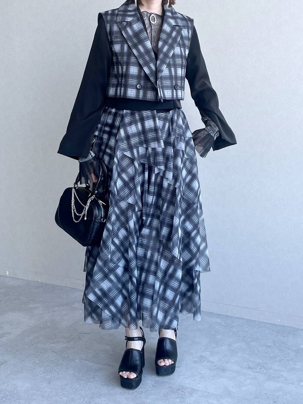 ブラック系のTシャツ/カットソー、ブラック系のテーラードジャケット、ブラック系のショルダーバッグを着用したレディースの春コーディネートの5枚目の写真