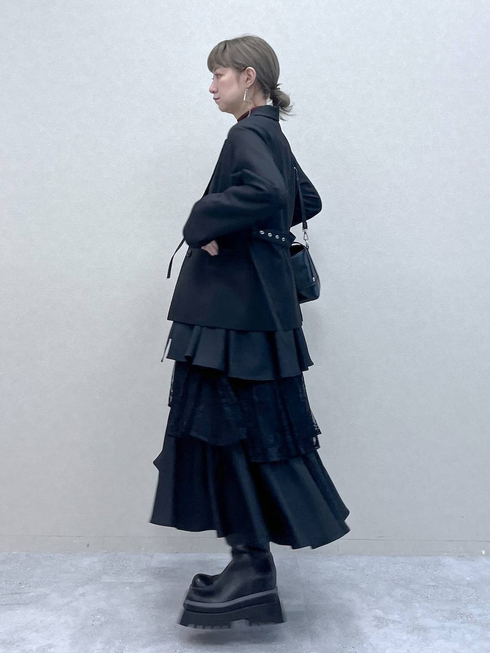 ブラック系のショルダーバッグ、その他のスカート、ブラック系のブーツを着用したレディースの秋コーディネートの6枚目の写真