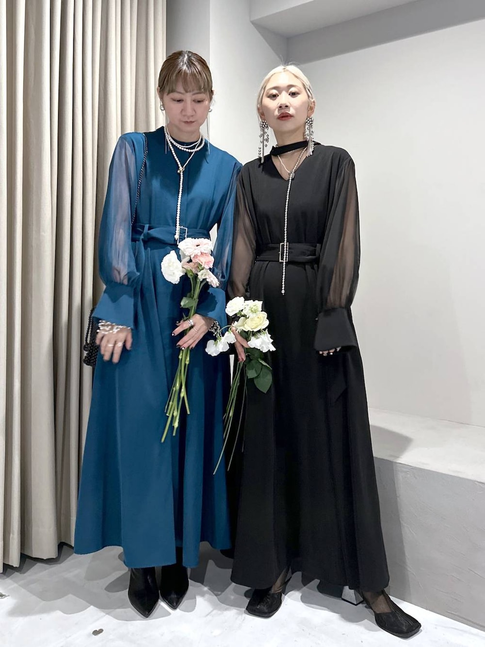 ブラック系のドレス、ブルー系のドレス、ブラック系のショルダーバッグを着用したレディースの冬コーディネートの6枚目の写真