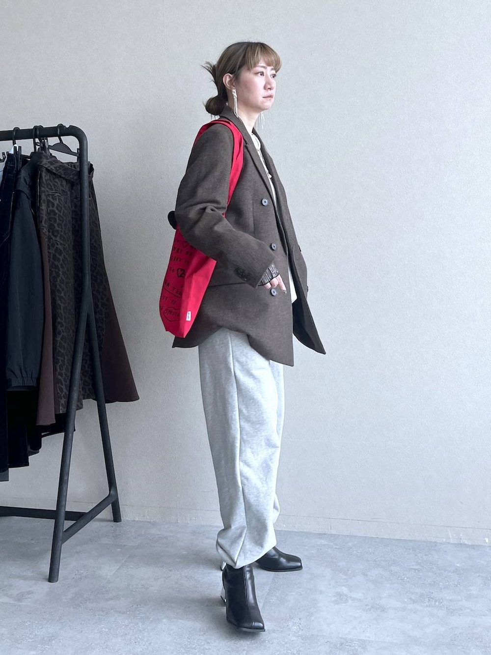 ブラック系のブーツ、レッド系のトートバッグ、グレー系のその他パンツを着用したレディースの冬コーディネートの5枚目の写真