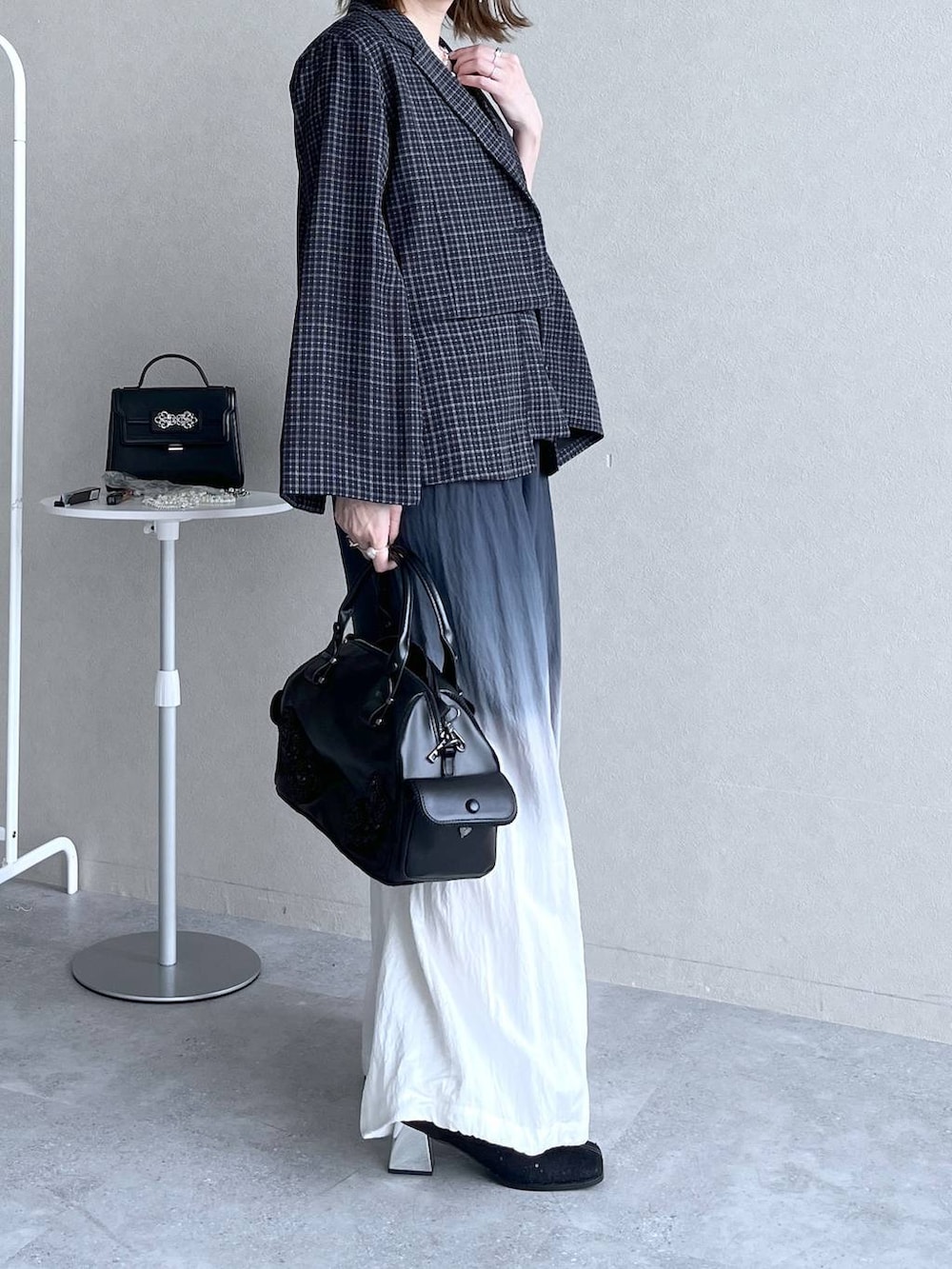 ブラック系のブーツ、ブラック系のボストンバッグ、ブラック系のその他パンツを着用したレディースの冬コーディネートの5枚目の写真