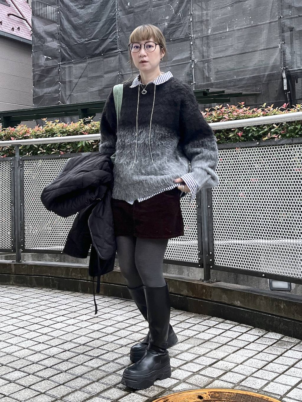 ブラック系のニット/セーターを着用したレディースの秋コーディネートの2枚目の写真