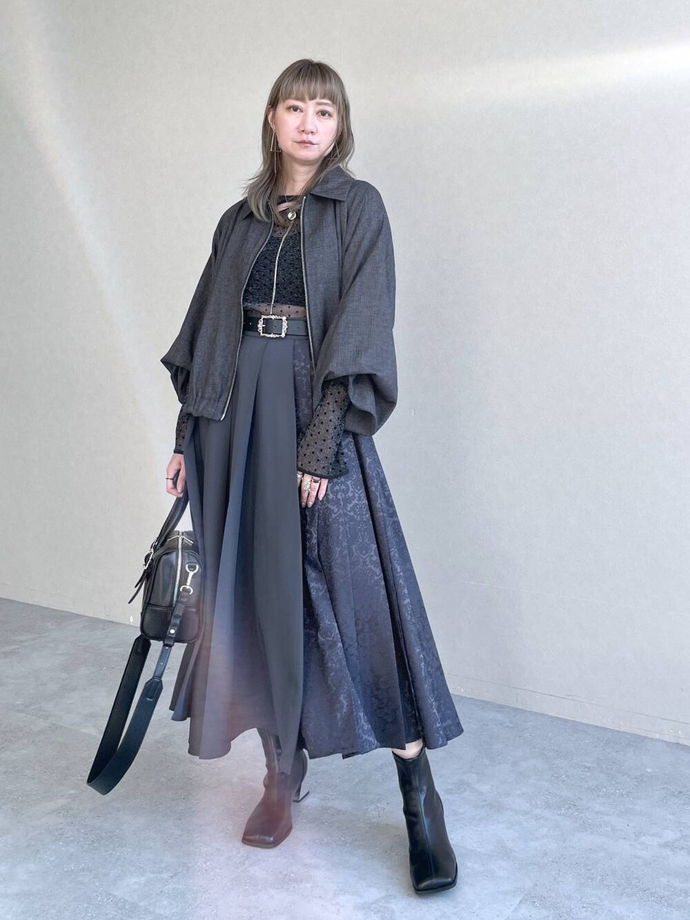 ブラック系のTシャツ/カットソー、ブラック系のボストンバッグ、ブラック系のブーツを着用したレディースの秋コーディネートの9枚目の写真