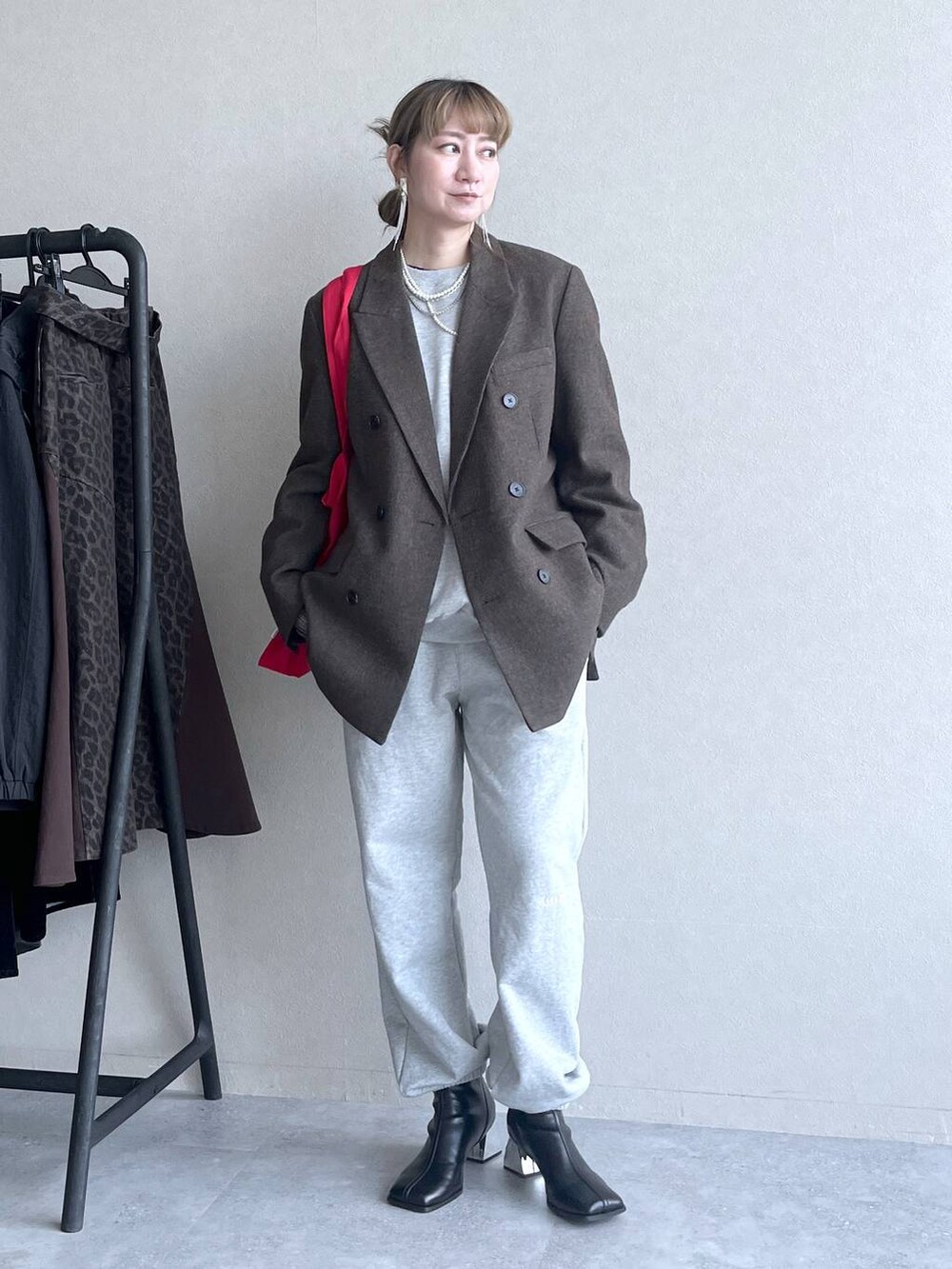 ブラック系のブーツ、レッド系のトートバッグ、グレー系のその他パンツを着用したレディースの冬コーディネートの8枚目の写真