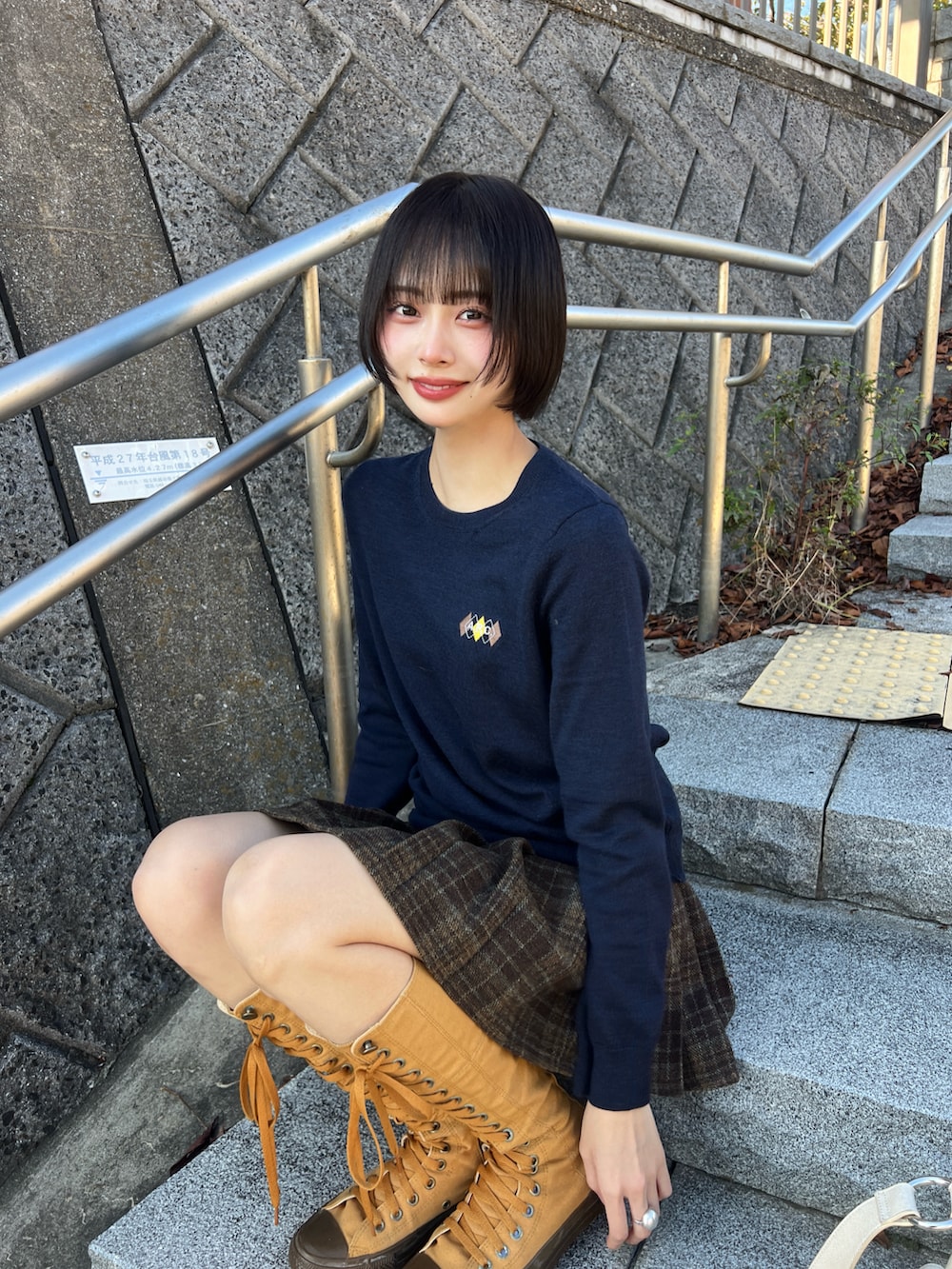 ブルー系のニット/セーター、ブラウン系のスカート、ブラウン系のブーツを着用したレディースの秋コーディネートの3枚目の写真