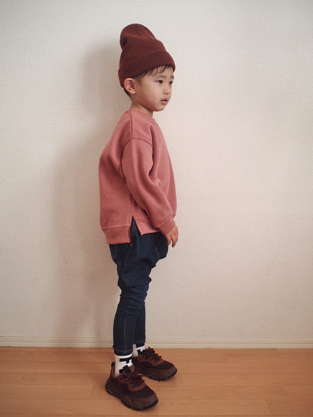 ピンク系のスウェット、ブルー系のデニムパンツ、ブラウン系のスニーカーを着用したキッズの冬コーディネートの3枚目の写真