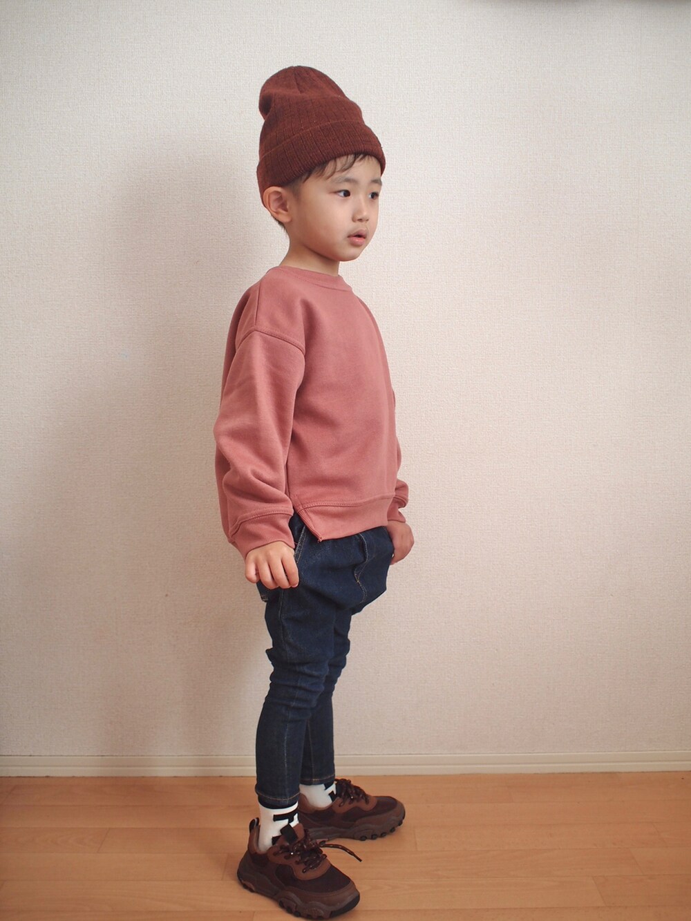 ピンク系のスウェット、ブルー系のデニムパンツ、ブラウン系のスニーカーを着用したキッズの冬コーディネートの5枚目の写真