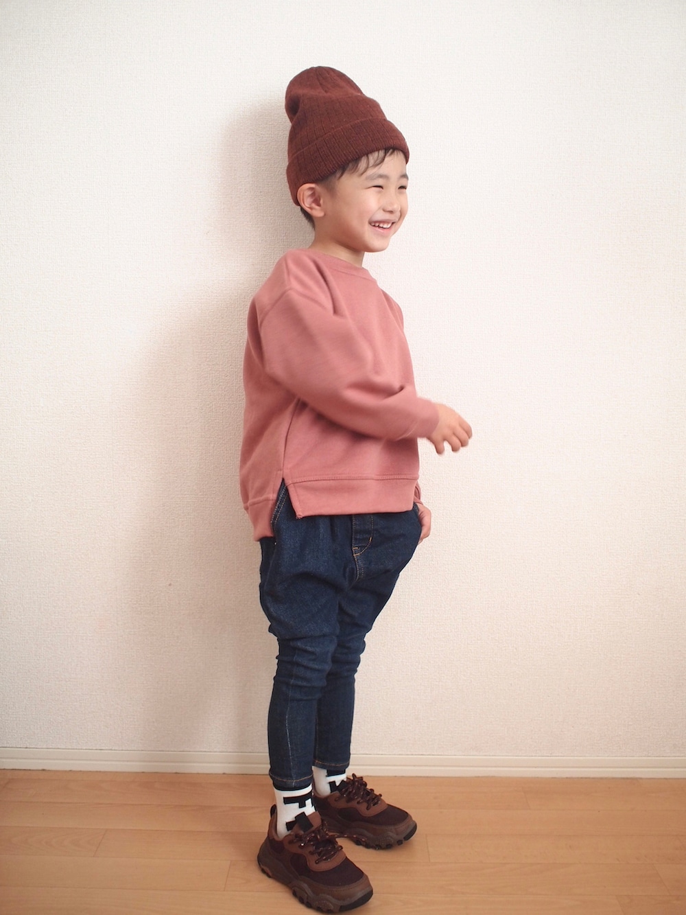 ピンク系のスウェット、ブルー系のデニムパンツ、ブラウン系のスニーカーを着用したキッズの冬コーディネートの4枚目の写真