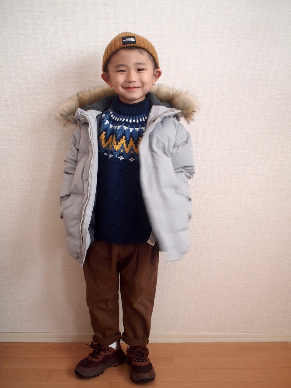 グレー系のダウンジャケット/コート、ブルー系のニット/セーター、ブラウン系のその他パンツを着用したキッズの冬コーディネートの2枚目の写真