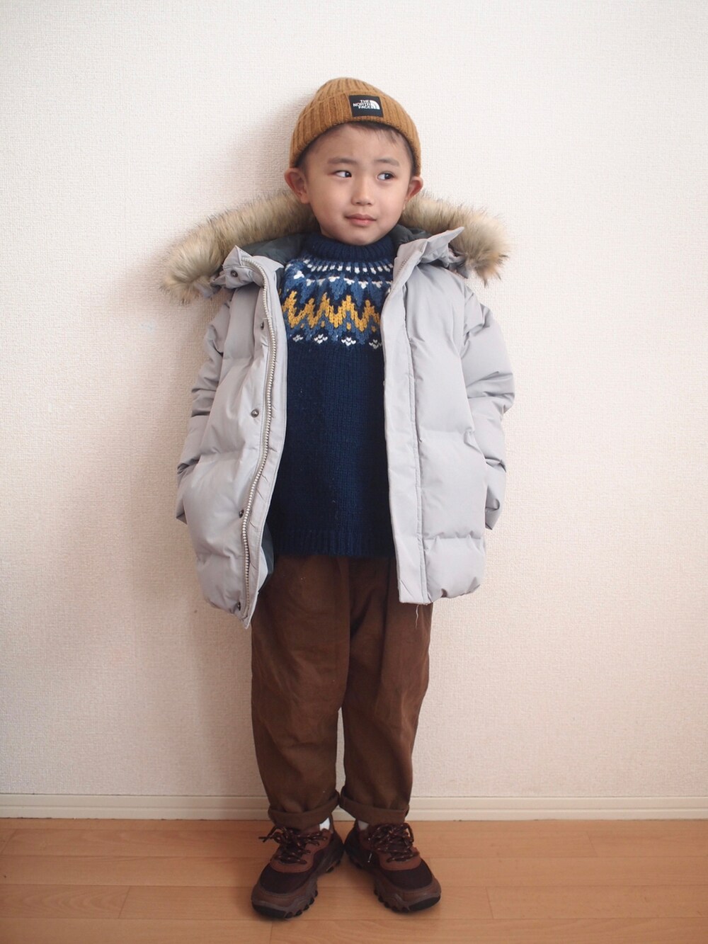 グレー系のダウンジャケット/コート、ブルー系のニット/セーター、ブラウン系のその他パンツを着用したキッズの冬コーディネートの3枚目の写真