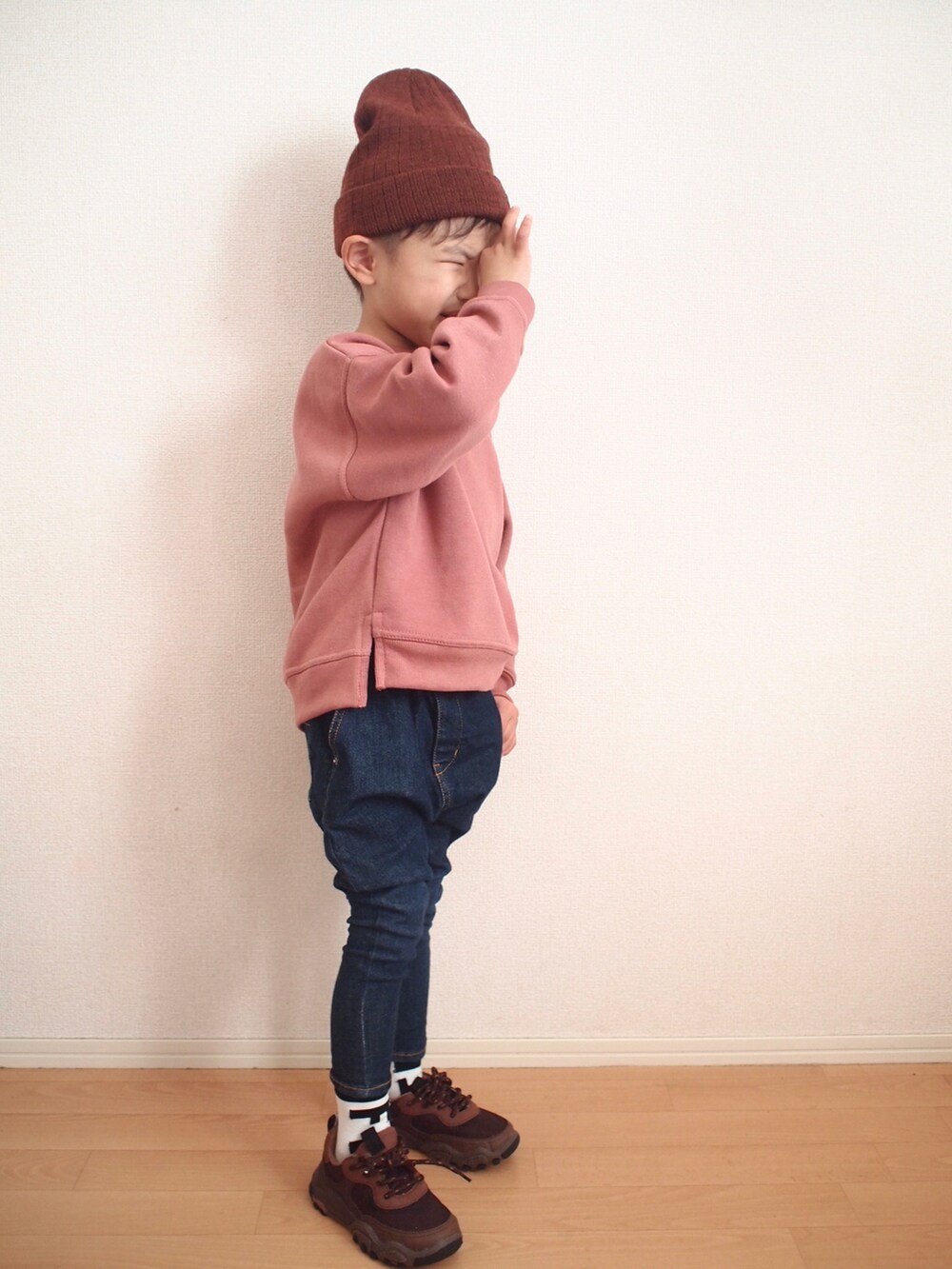 ピンク系のスウェット、ブルー系のデニムパンツ、ブラウン系のスニーカーを着用したキッズの冬コーディネートの2枚目の写真
