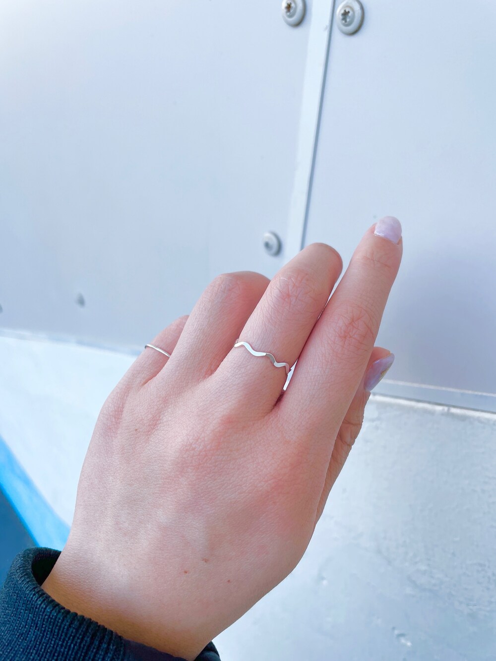 ベージュ系のカーディガン/ボレロ、ブラック系のワンピース、ホワイト系のブーツを着用したレディースの冬コーディネートの2枚目の写真