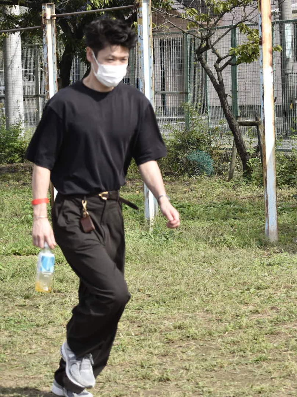 ブラック系のTシャツ/カットソー、ブラウン系のスラックス、グレー系のスニーカーを着用したメンズの秋コーディネートの2枚目の写真