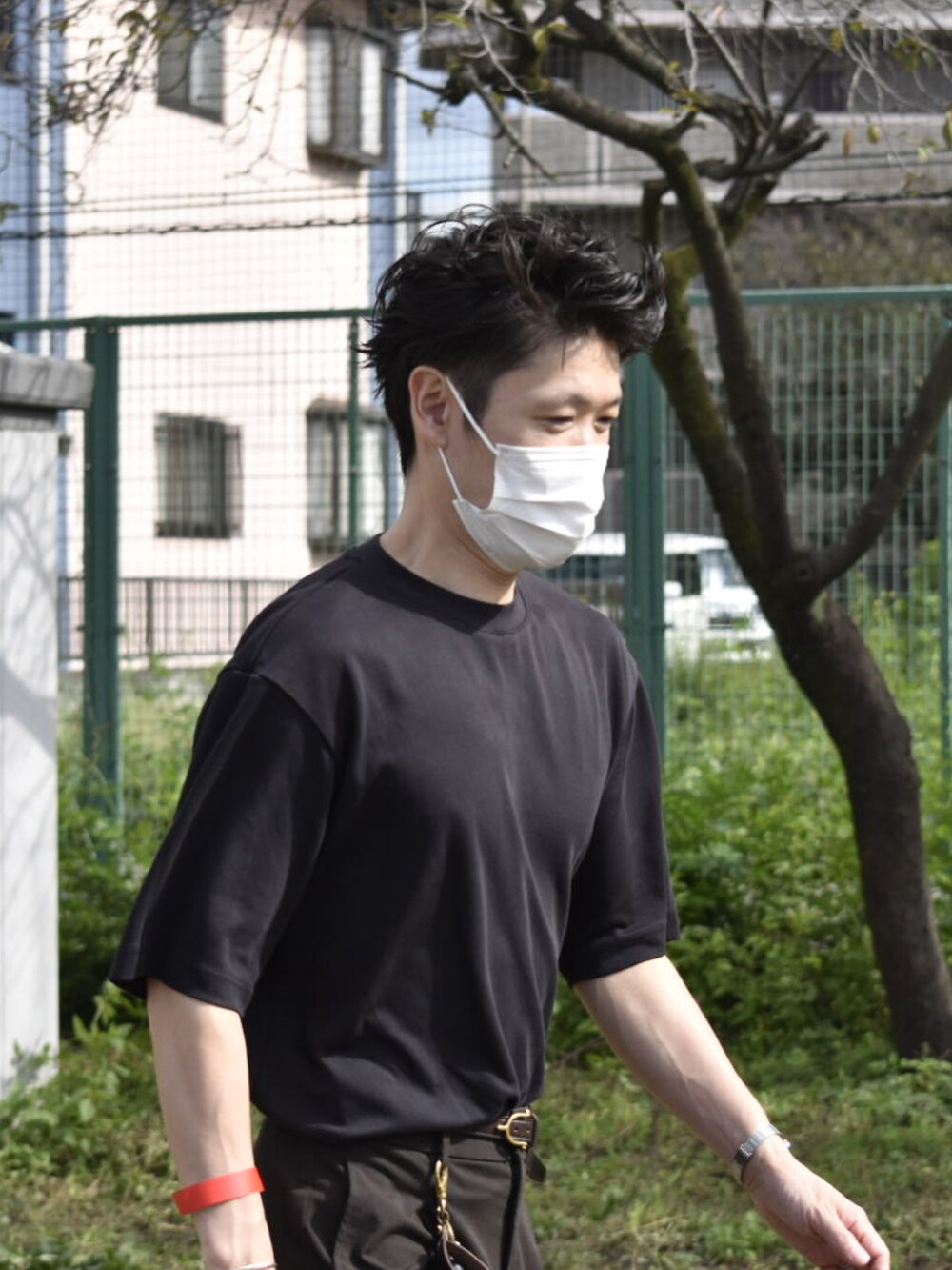 ブラック系のTシャツ/カットソー、ブラウン系のスラックス、グレー系のスニーカーを着用したメンズの秋コーディネートの4枚目の写真