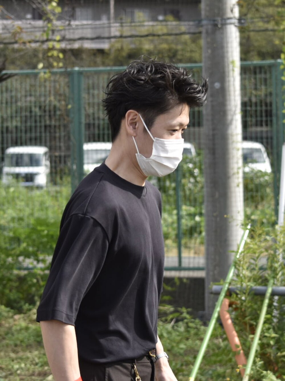 ブラック系のTシャツ/カットソー、ブラウン系のスラックス、グレー系のスニーカーを着用したメンズの秋コーディネートの5枚目の写真