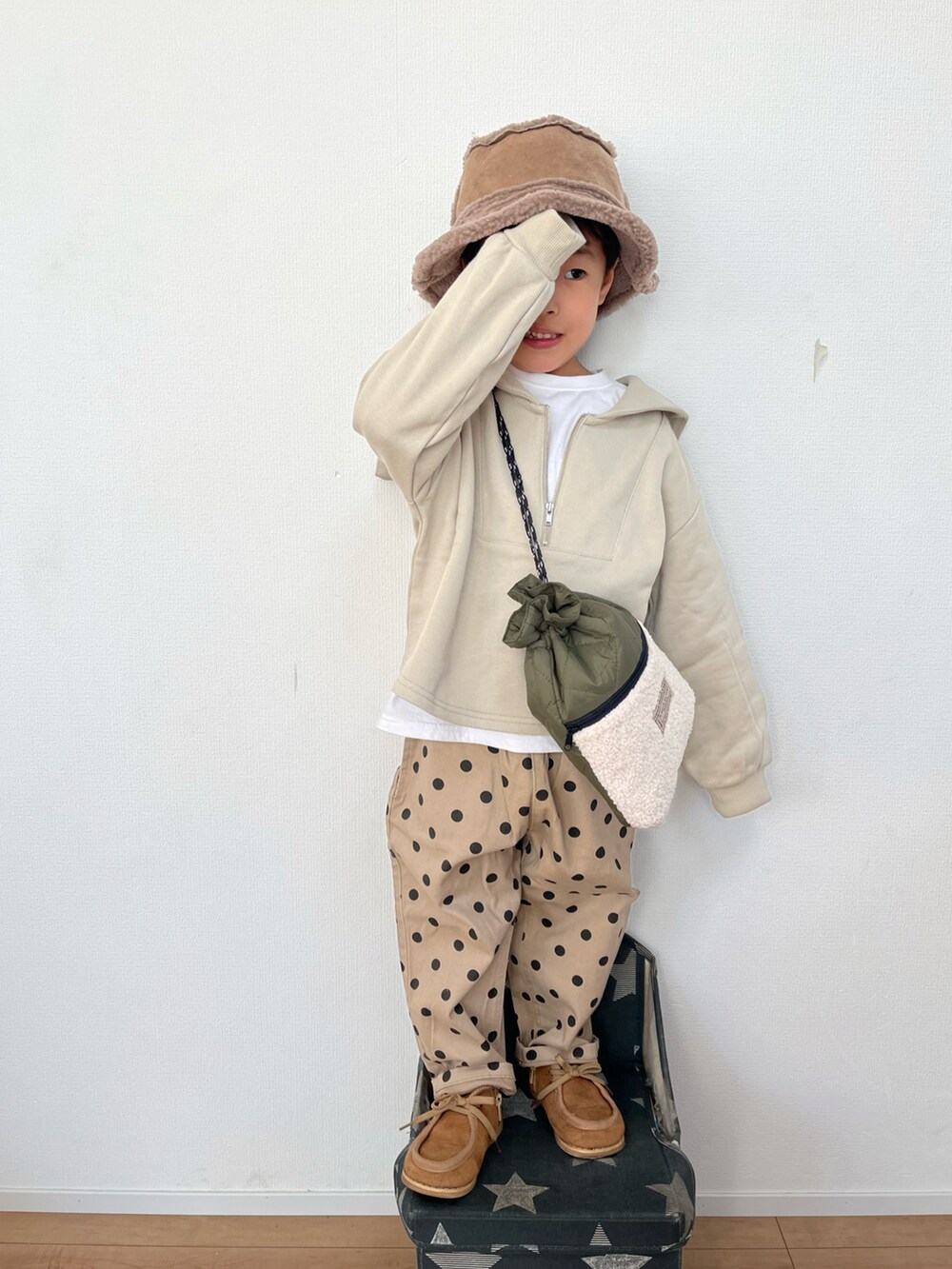 グリーン系のショルダーバッグ、ホワイト系のTシャツ/カットソー、ベージュ系のその他パンツを着用したキッズの冬コーディネートの2枚目の写真