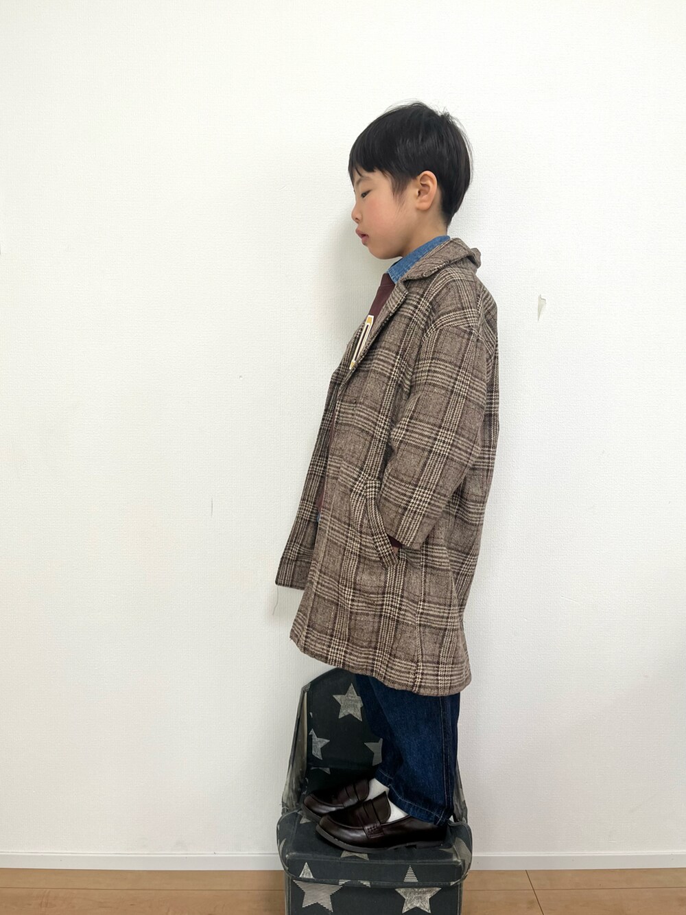ブラウン系のチェスターコート、ブラウン系のスウェット、ブルー系のシャツ/ブラウスを着用したキッズの冬コーディネートの3枚目の写真